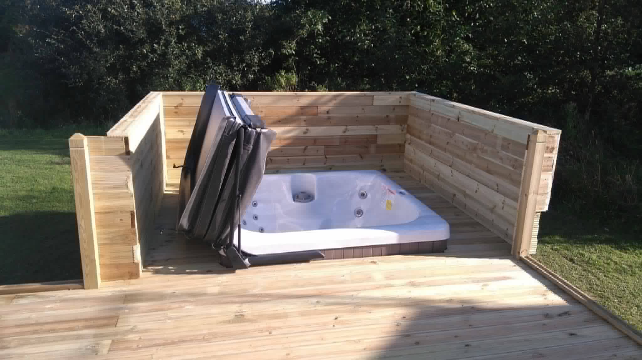 Raised timber lodge decking area with hot tub and privacy screening