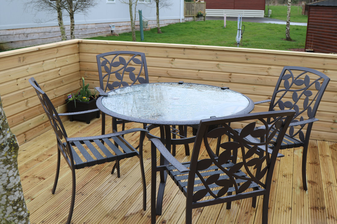 Timber lodge decking with dining furniture and enclosed balustrade